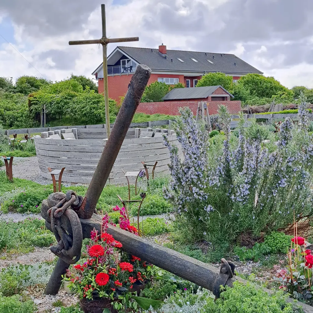 großer Anker geschmückt mit abgelegten Blumen