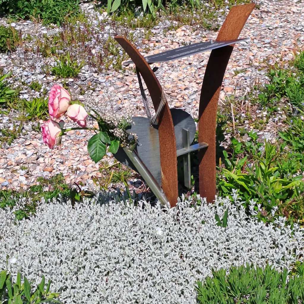 Stele mit kleiner Vase und einzelnen Rosenblüten