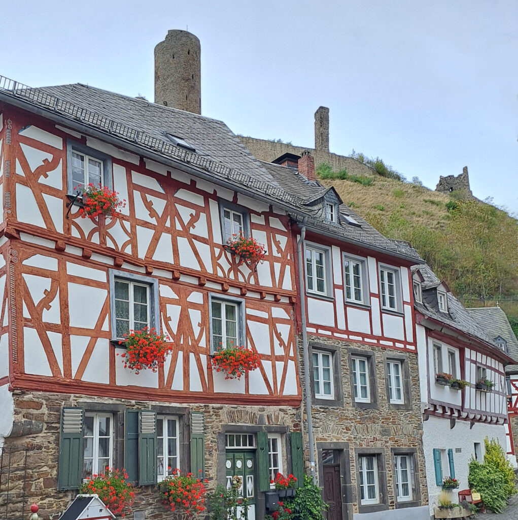 Fachwerkhaus mit Burgruine im Hintergrund
